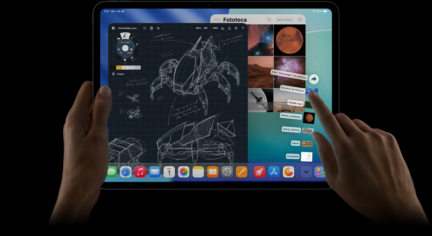 iPad Pro, parte frontal, posición horizontal, una mano derecha hace un gesto sobre archivos de la carpeta de descargas ubicados en forma de abanico, la pantalla muestra la interfaz de iPadOS 26 con varias apps abiertas incluida una app de edición de fotos que muestra los planos detallados de un robot y notas escritas a mano, varias etapas del diseño y la fototeca