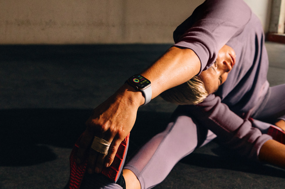Une personne portant une Apple Watch Series 10 s’étire en faisant une posture de yoga.