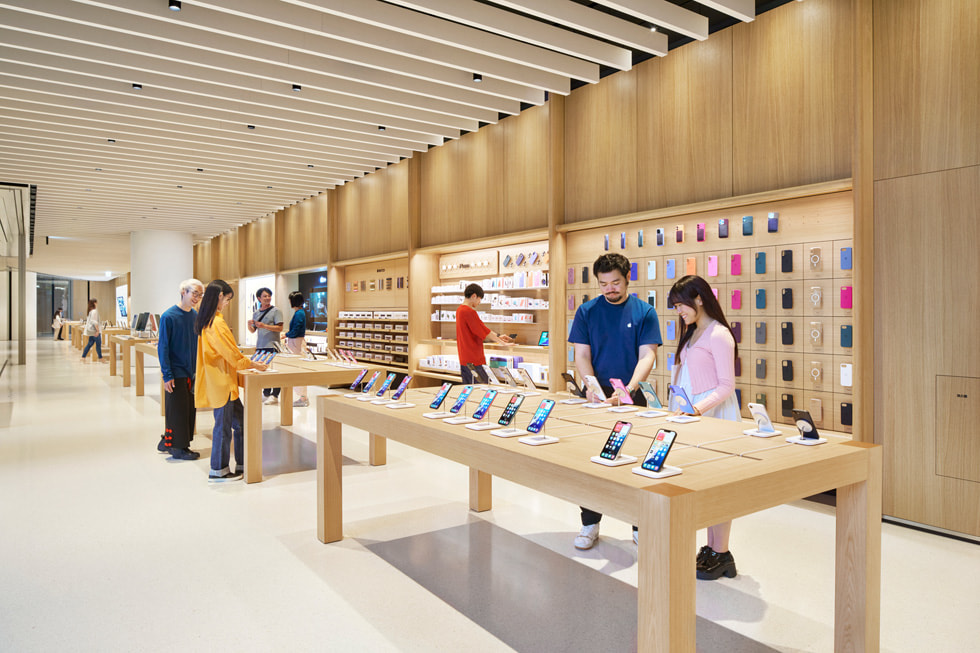 Apple 梅田の店内にいるチームメンバーとお客様。