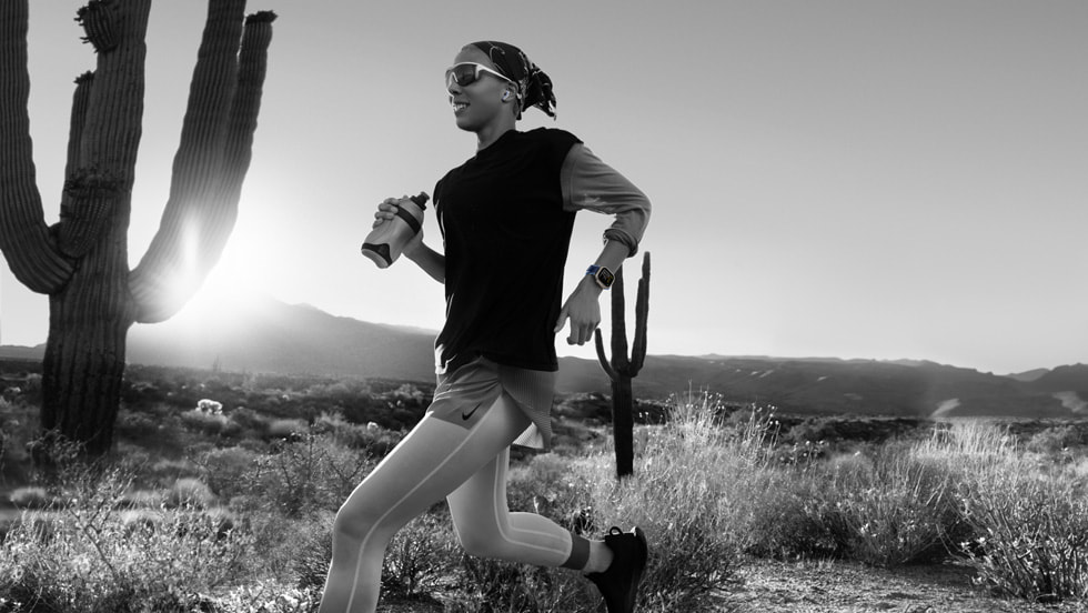 Une photo en noir et blanc d’une personne qui court dans un paysage désertique avec une Apple Watch Ultra 3.