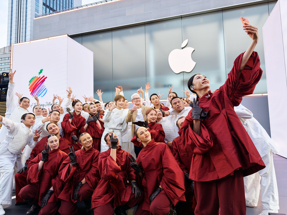 Tim Cook is pictured posing for a selfie with Chris Lee and dancers in white and red costumes at Apple Taikoo Li Chengdu in China.