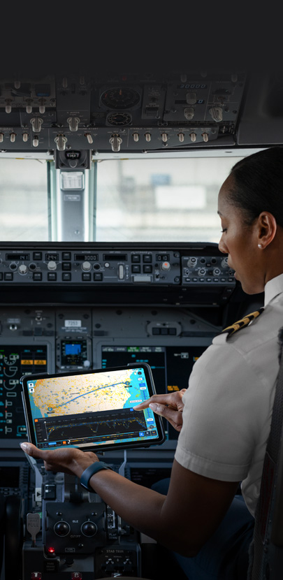 A pilot in a cockpit looking at a map on an iPad screen.