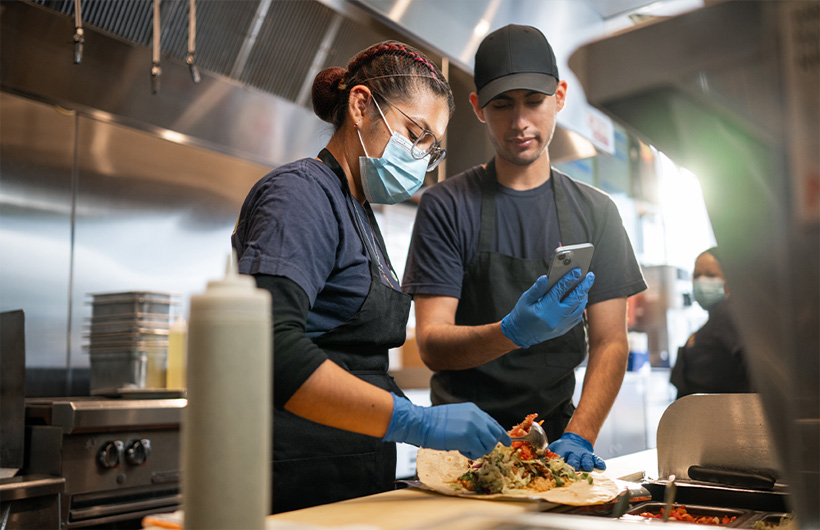 Una empleada aprende a enrollar un burrito al «estilo Sisig».