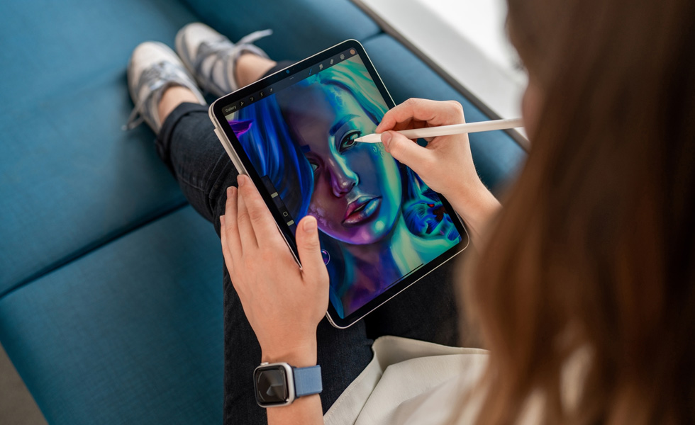 Eine Studentin hält ein iPad auf ihrem Schoss und zeichnet mit einem Apple Pencil in der Procreate App