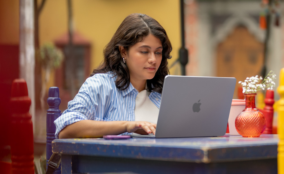 Eine Studentin tippt auf ihrem MacBook