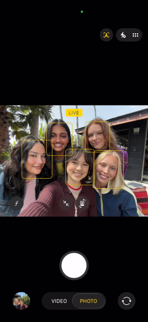 iPhone 17, voorkant, op het scherm een groepsselfie met de feature Middelpunt voor foto’s