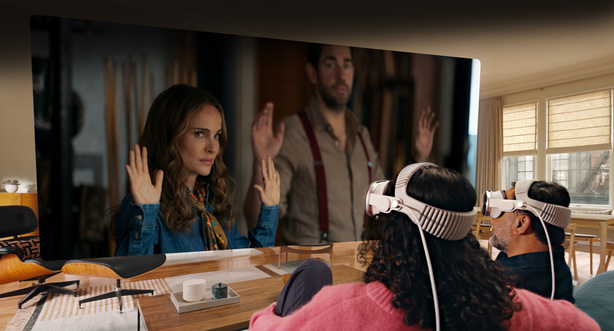 Zwei Personen, die beide eine Apple Vision Pro tragen, sitzen nebeneinander auf der Couch und schauen sich den Film Fountain of Youth an, wobei sich der Bildschirm über den ganzen Raum erstreckt{